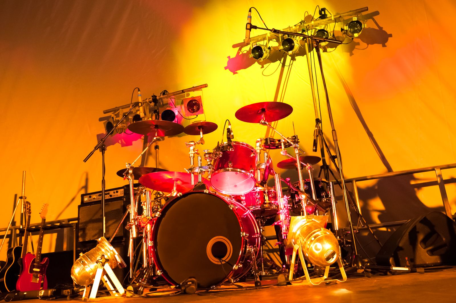 Escenario de concierto con batería, guitarras y focos