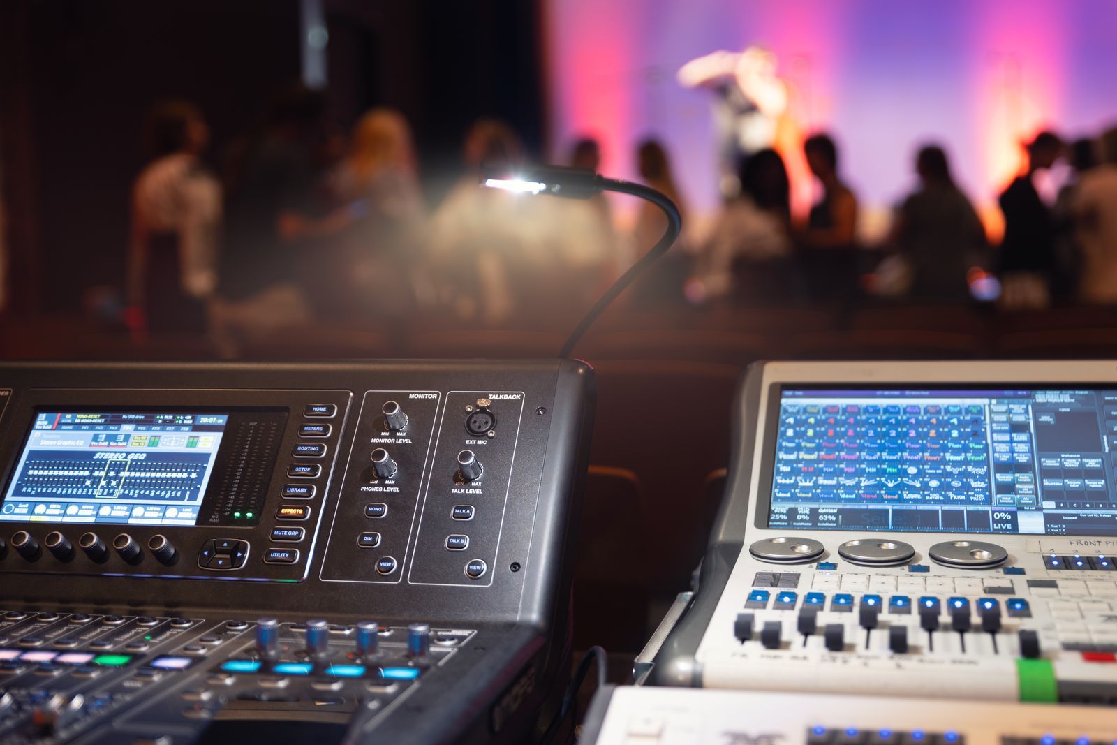 Mesas de control de sonido y vídeo frente al escenario de un teatro