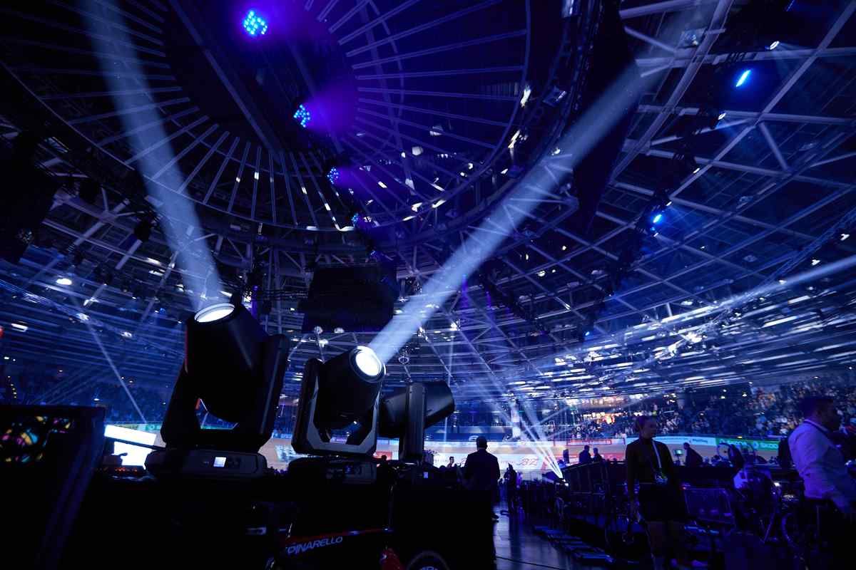 Cabezas móviles proyectando haces de luz sobre el público de un evento