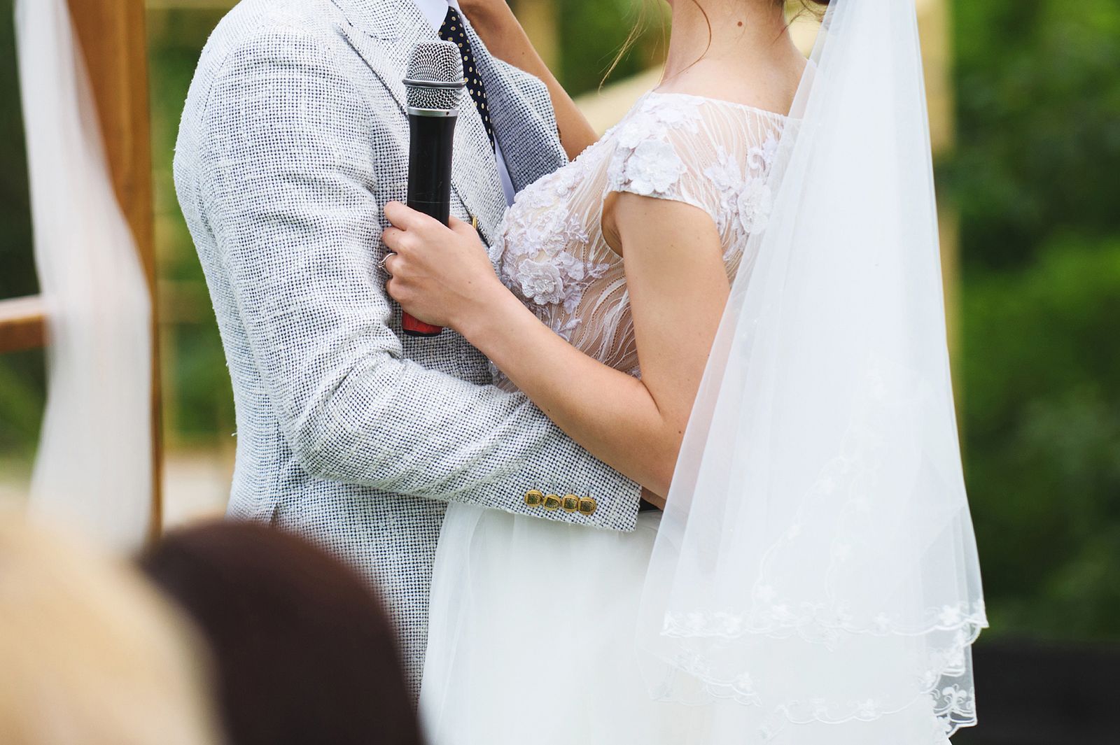 Los novios abrazados con un micrófono en la mano
